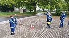 Die Jugendgruppe übt mit einer Wasserflasche Becher zu füllen, die in einem unüberwindbaren Ring stehen